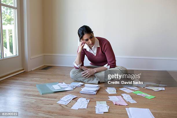 woman looking at bills and receipts on floor - large group of objects stock pictures, royalty-free photos & images