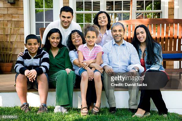 multigenerational hispanic family on porch - multigenerational family diverse stock pictures, royalty-free photos & images