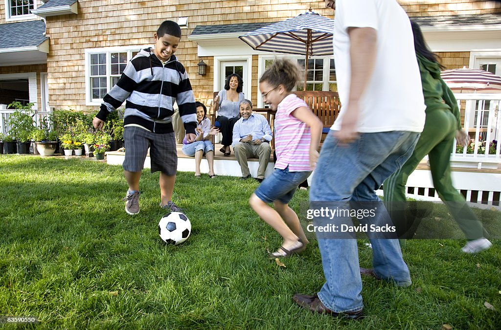 Familie Fußball spielen im Vorort Garten