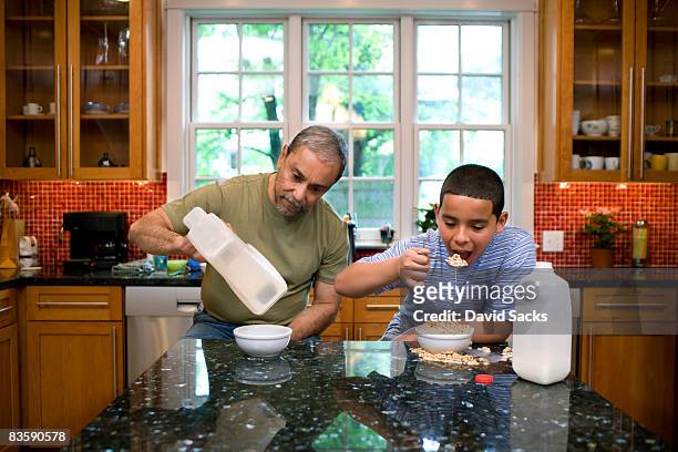 junge und großvater in der küche essen frühstück - egoismus stock-fotos und bilder