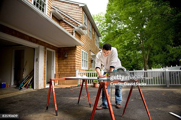 mann arbeitet in auffahrt - elektrisches werkzeug stock-fotos und bilder