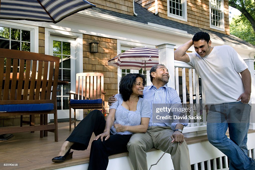 Parents and son talking on back porch