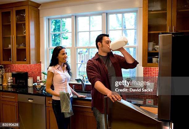 couple in kitchen - melkpak stockfoto's en -beelden