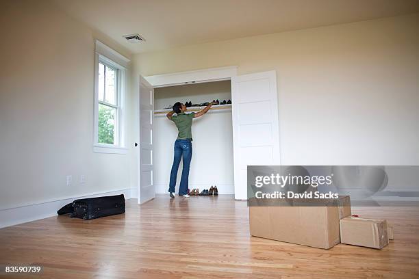 frau ziehen sie die schuhe in kleiderschrank des neuen zuhause - personalised stock-fotos und bilder