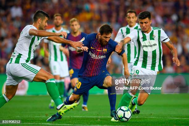 Barcelona's Argentinian forward Lionel Messi vies with Betis' forward Alex Alegria and Betis's Colombian forward Juan Narvaez during the Spanish...