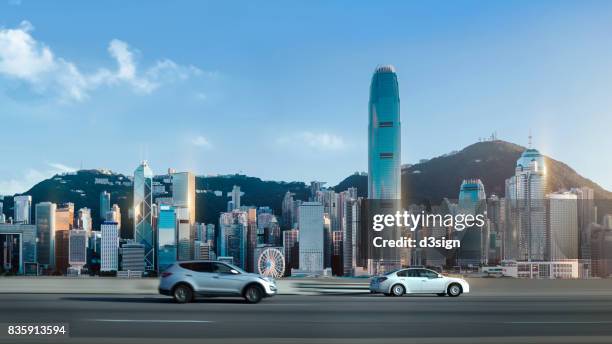 traffic on street against hong kong cityscape with clear blue sky - auto modern stock-fotos und bilder