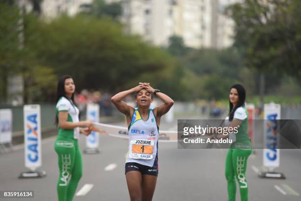 Joziane Aparecida Cardoso of Brazil crosses the finish line in third place during the Rio de Janeiro International Women's Half Marathon in Rio de...