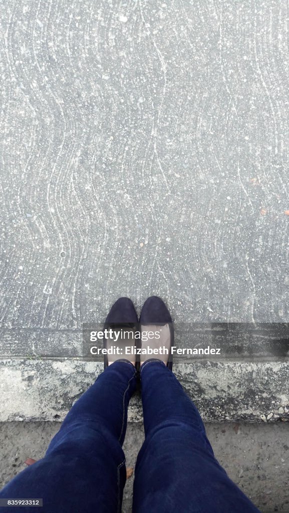 Low Section Of Woman Standing On Concrete