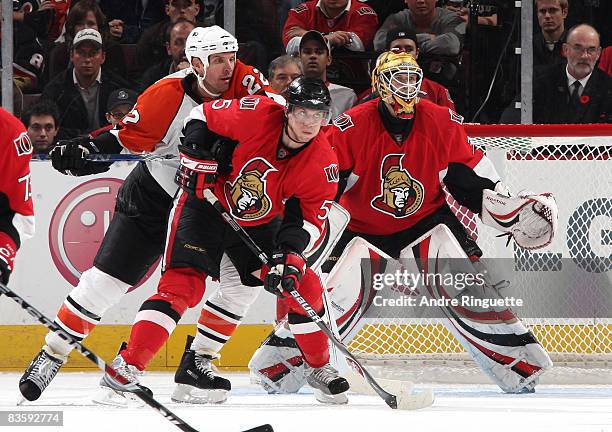 Christoph Schubert and Alex Auld of the Ottawa Senators defend their crease against Mike Knuble of the Philadelphia Flyers at Scotiabank Place on...