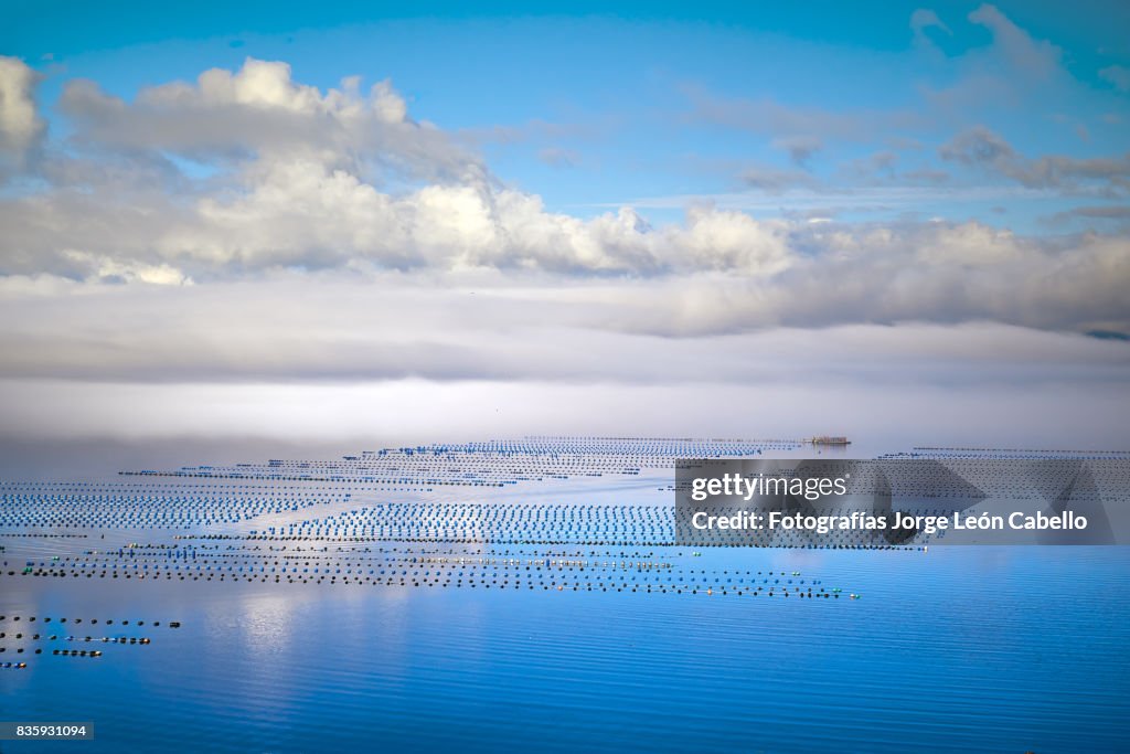 A view of the seafood farms in Yal canal with low clouds and some reflections.