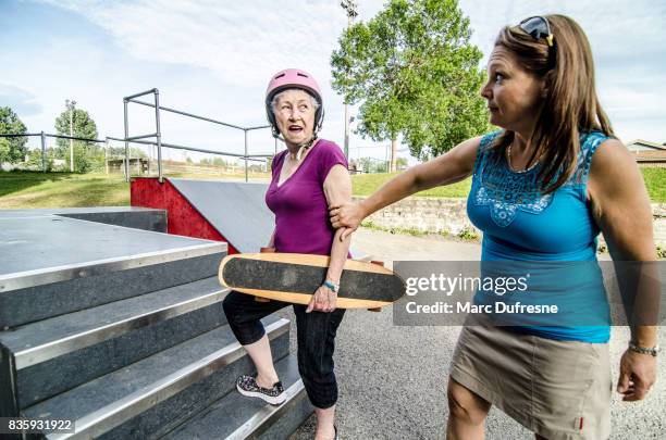 junge frau versucht, ältere frau skate skateboard rampe treppe hinauf zu stoppen - coole oma stock-fotos und bilder