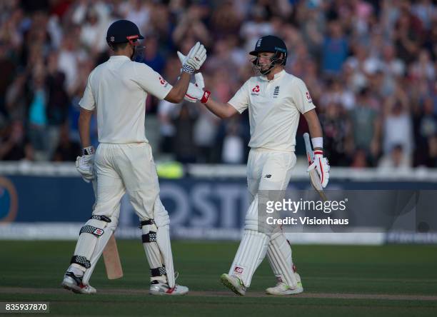 Joe Root of England celebrates his century and is congratulated by Alastair Cook during day one of the 1st Investec test match between England and...