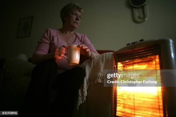 In this photo illustration an old age pensioner keeps warm with the aid of an electric heater on November 6 in Conwy, Wales. With the recent high...