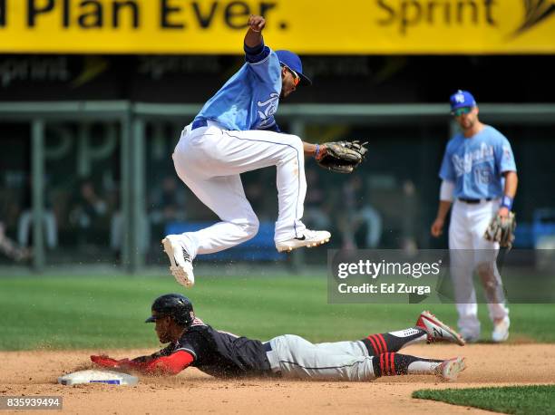 Alcides Escobar of the Kansas City Royals leaps over Francisco Lindor of the Cleveland Indians as Lindor slides safely into second for a steal in the...