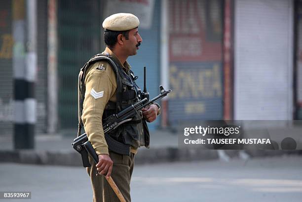 An Indian Central Reserve Police Force soldier patrols along the main commercial hub of Lal Chowk in Srinagar during a second day of a curfew on...