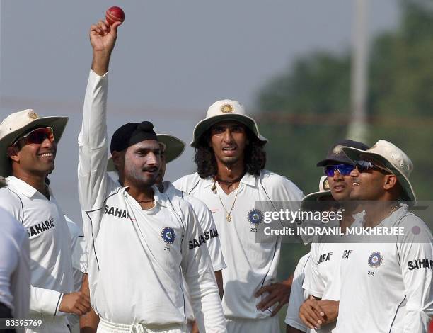 Indian cricketer Harbhajan Singh celebrates with teammates after taking the wicket of unseen Australian batsman Ricky Ponting, to claim his 300th...