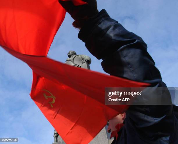 Belarus man holds a banner at a rally marking the 91st anniversary of the October revolution near a monument to Vladimir Lenin, the founder of the...