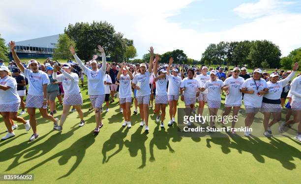 The players of Team USA walk down the 18th fairway linked arm in arm after the final day singles matches of The Solheim Cup at Des Moines Golf and...