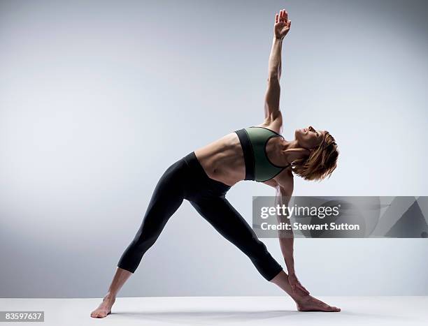 woman in yoga pose - breitbeinig stehen stock-fotos und bilder