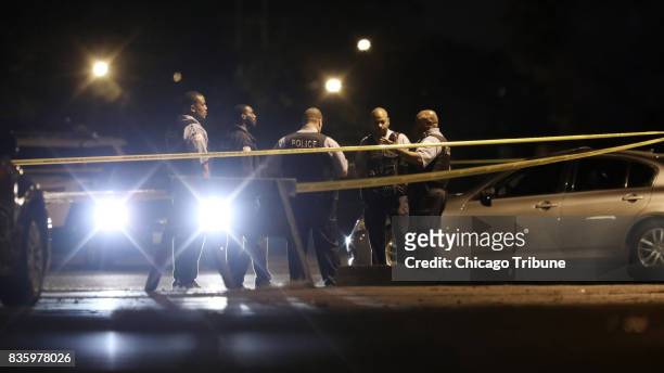 Police officers guard a crime scene in the parking lot of an event center in the 11900 block of South Loomis Street on Sunday, Aug. 20 in Chicago,...
