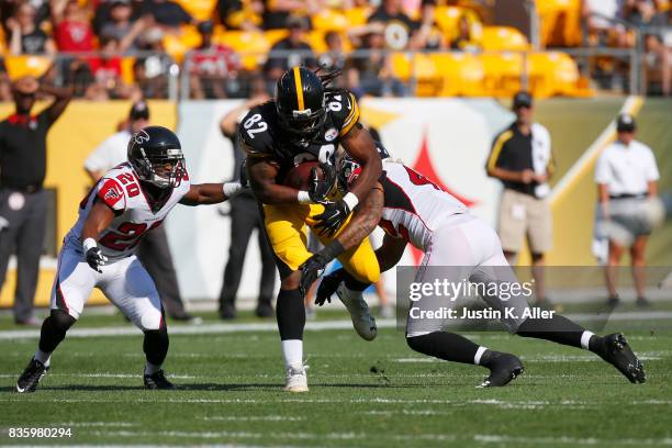 David Johnson of the Pittsburgh Steelers runs after the catch against Sharrod Neasman and Duke Riley of the Atlanta Falcons during a preseason game...