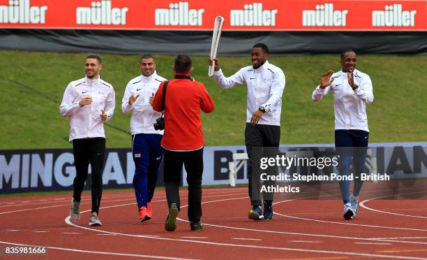 Chijindu Ujah, Adam Gemili, Daniel Talbot and Nethaneel Mitchell-Blake of Great Britain carry the Commonwealth baton around the track during the...