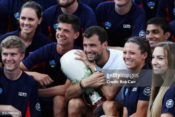 Grigor Dimitrov of Bulgaria poses with ball persons after defeating Nick Kyrgios of Australia to win the men's final during Day 9 of of the Western...