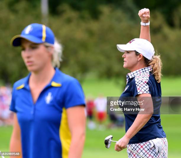 Cristie Kerr of Team USA celebrates a two and one win as Melissa Reid of Team Europe leaves the 17th green during the final day singles matches of...