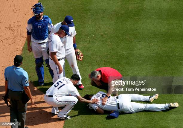 Joey Gallo of the Texas Rangers lays on the field after colliding with Matt Bush of the Texas Rangers while fielding the ball against the Chicago...
