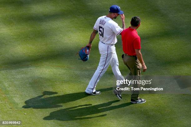 Matt Bush of the Texas Rangers leaves the game after colliding with Joey Gallo of the Texas Rangers while fielding the ball against the Chicago White...