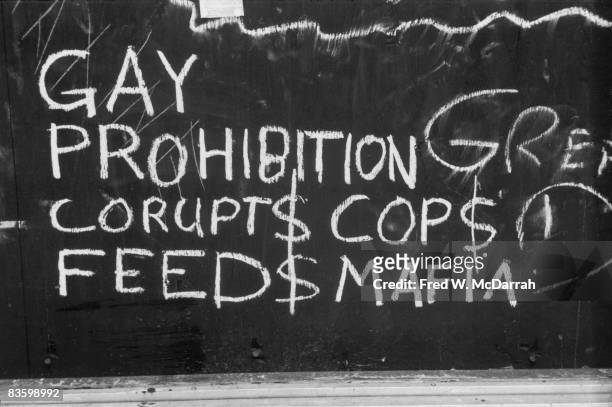 Close-up of handwritten chalk text on a boarded-up window of the Stonewall Inn after riots over the weekend of June 27, 1969. The text reads 'Gay...