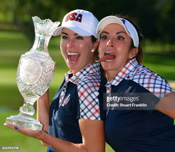 Paula Creamer and Gerina Piller of Team USA hold the Solheim Cup trophy after the final day singles matches of The Solheim Cup at Des Moines Golf and...