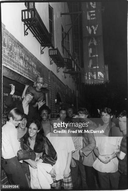 An unidentified group of young people celebrate outside the boarded-up Stonewall Inn after riots over the weekend of June 27, 1969. The bar and...