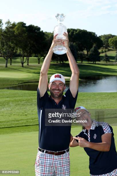 Brady Stockton the caddie of Cristie Kerr of the United States Team holds the Solheim Cup high above her after the closing ceremony during the final...