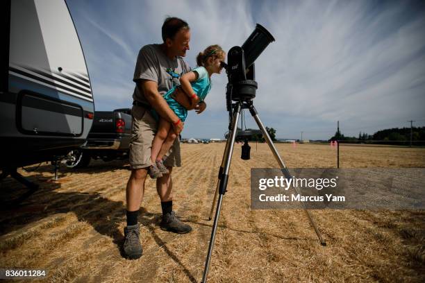 Jeff Thornton carries his daughter, Sammie to view the sun as they camp at French Prairie Gardens & Family Farm for a peaceful and unobstructed view...