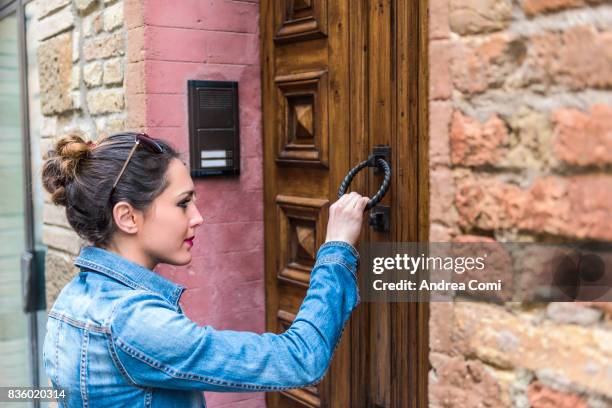 montalcino, siena, tuscany. a girl knocking at a door - knocking photos et images de collection