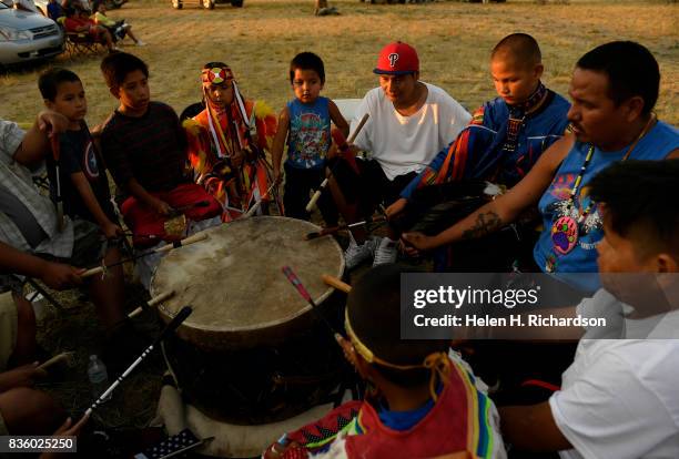 Members of the Northern Arapaho tribe drum group called the Young Falcons play during a local tribal pow wow on the eve of the great American Eclipse...