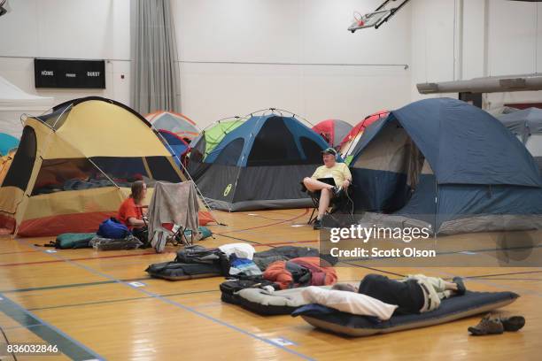 Campers, in town to view the solar eclipse, relax at their indoor campsites on the campus of Southern Illinois University the evening before Monday's...