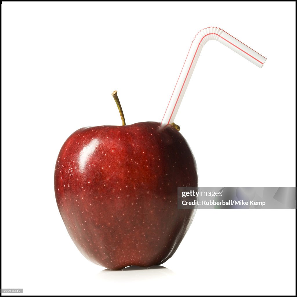 Red delicious apple with a straw in it
