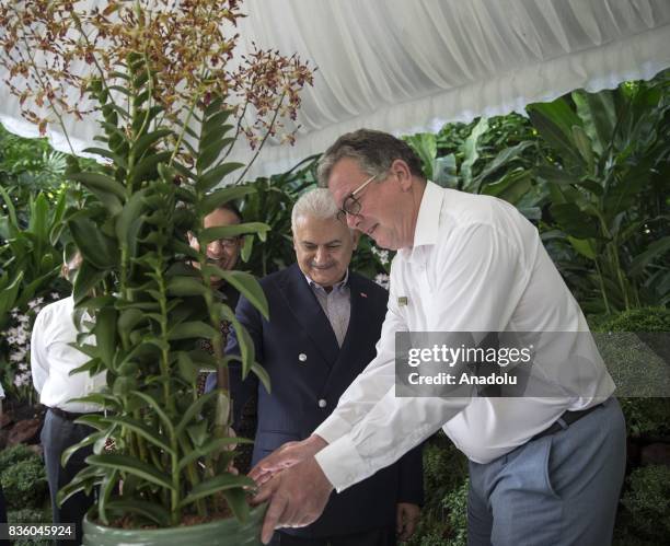 Turkish Prime Minister Binali Yildirim views a dendrobium orchid named after him with Singapore's Minister for Trade and Industry S. Iswaran and...
