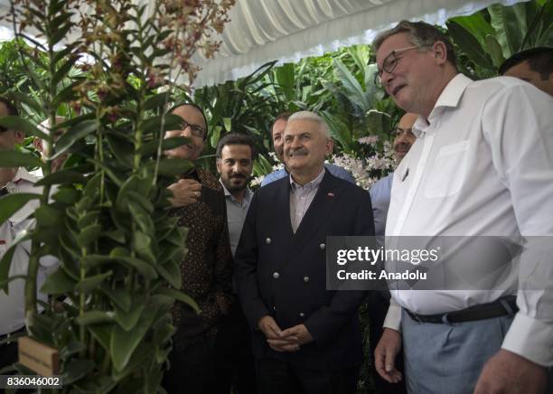 Turkish Prime Minister Binali Yildirim views a dendrobium orchid named after him with Singapore's Minister for Trade and Industry S. Iswaran and...