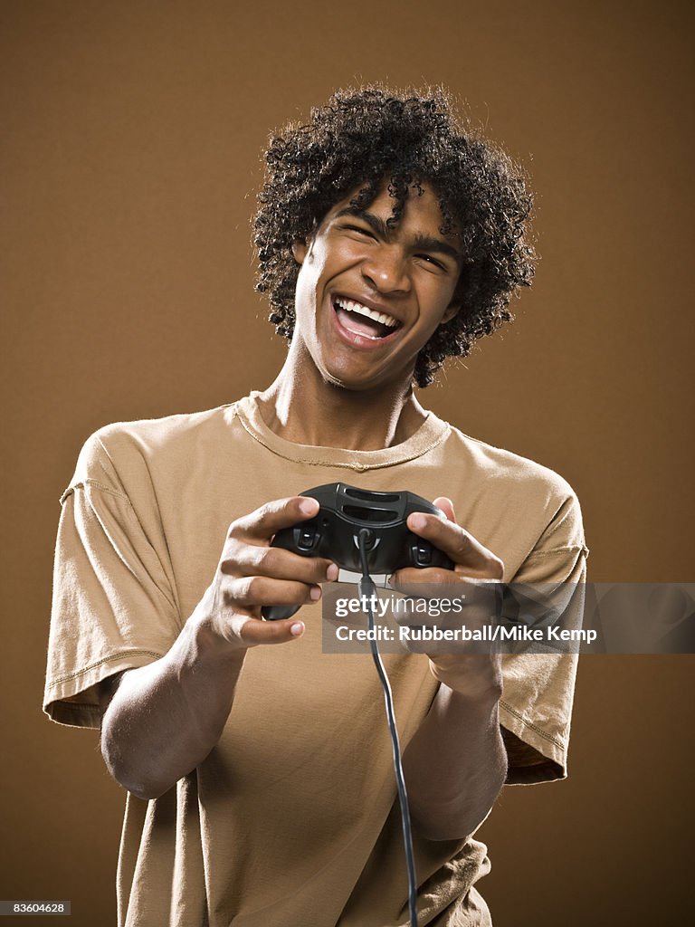 Young man in a brown shirt playing a video game.