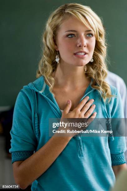 young woman with hand over heart. - amerikanischer treueschwur stock-fotos und bilder
