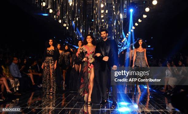 Indian Bollywood actors Jacqueline Fernandez and Aditya Roy Kapur showcase a creation by designer Manish Malhotra during the grand finale of Lakme...