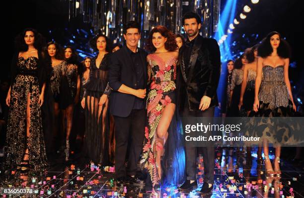 Indian Bollywood actors Jacqueline Fernandez and Aditya Roy Kapur showcase a creation by designer Manish Malhotra during the grand finale of Lakme...