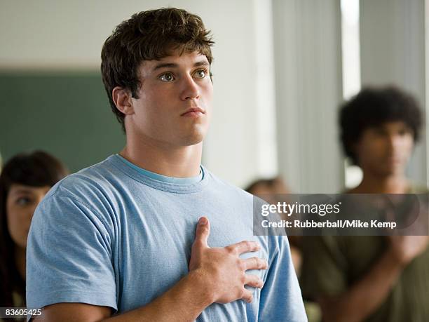 young man with hand over heart. - amerikanischer treueschwur stock-fotos und bilder