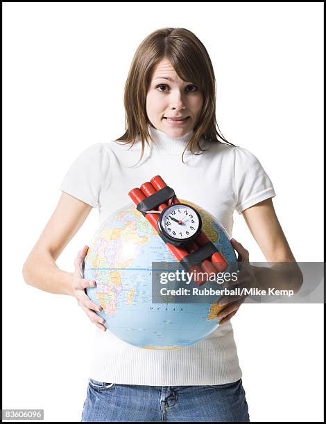 woman holding dynamite on the earth - comportamento autodestrutivo imagens e fotografias de stock