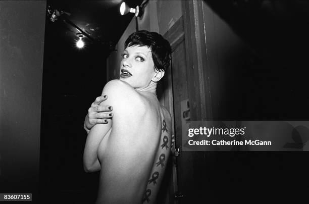 Model Kristen McMenamy poses for a photo and shows off the AIDS awareness ribbons painted on her back at an AmFar Benefit at Webster Hall in February...