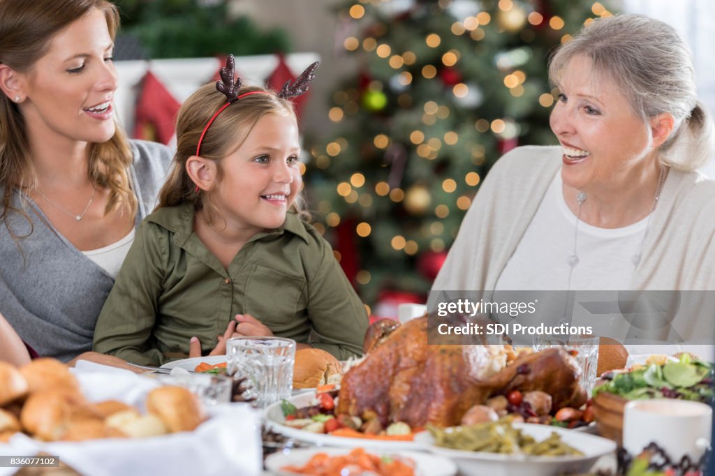 Trois générations de femmes rire et visiter pendant le dîner de Noël