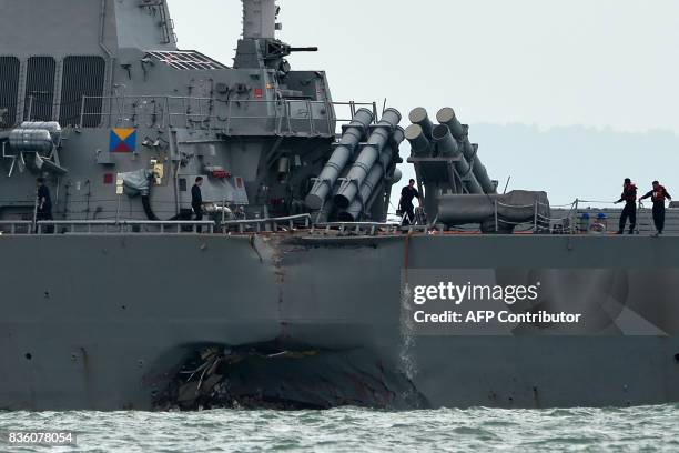 The guided-missile destroyer USS John S. McCain is seen with a hole on its portside after a collision with an oil tanker outside Changi naval base in...